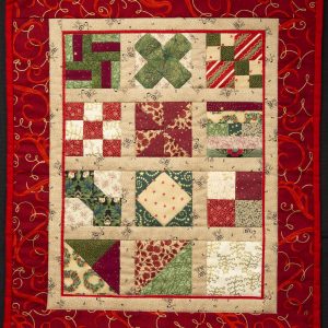 Twelve Days of Christmas - Quilt featuring festive red material used for the border with 12 blocks in the center made from several different patterned fabrics