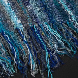 Fiber Arts - Memories of Mom in Blue - Detail - Blue throw made out of several textures of yarn to give it a very soft look and feel finished off with fringe on the top and bottom end.