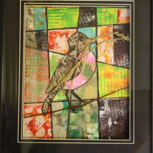 Mixed Media Crafts - A Many Splendored World - Framed image of colorful bird with wild oats near the beak all set on colored background that mimics stained glass.