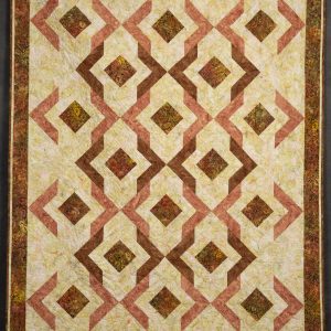 Quilting - Butterscotch Delight - quilt of various V and square shaped patterned fabrics in colors of orange, brown, gold and peachen patterned fabrics placed side to side that creates unique rows of design.