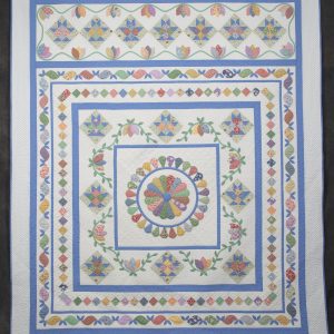 Quilting - Its Blue and 30 - quilt made of various colorful fabrics with blue as the main color used in a layered frame theme. The center medallion is made from a variety of colorful fabrics in teardrop shapes to form a medallion. The center medallion is framed in blue fabric and surrounded by rows of baskets and swag applique.