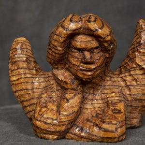 Sculpture 3D - Cherub - sculpture of a cherub bust with wings carved out of wood leaning forward on crossed arms with one hand on cheek of face as if contemplating something. The wood used to make the sculpture has horizontal dark lines through the entire sculpture which gives it a unique look.