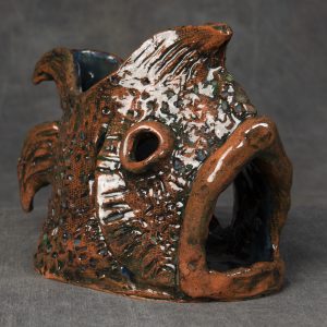 Sculpture 3D - Terri Ann Fishsinger - sculpture of a fish made from ceramic or clay that has various design elements on the body and fins. The mouth of the fish is very large and is open, as well as an opening on the top and through the eyes.